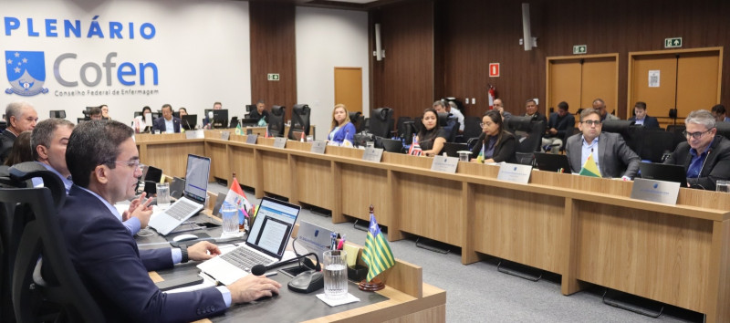 Um grupo de pessoas em volta de uma mesa, em uma reunião