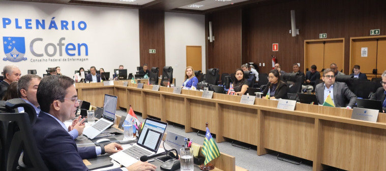 Um grupo de pessoas em volta de uma mesa, em uma reunião
