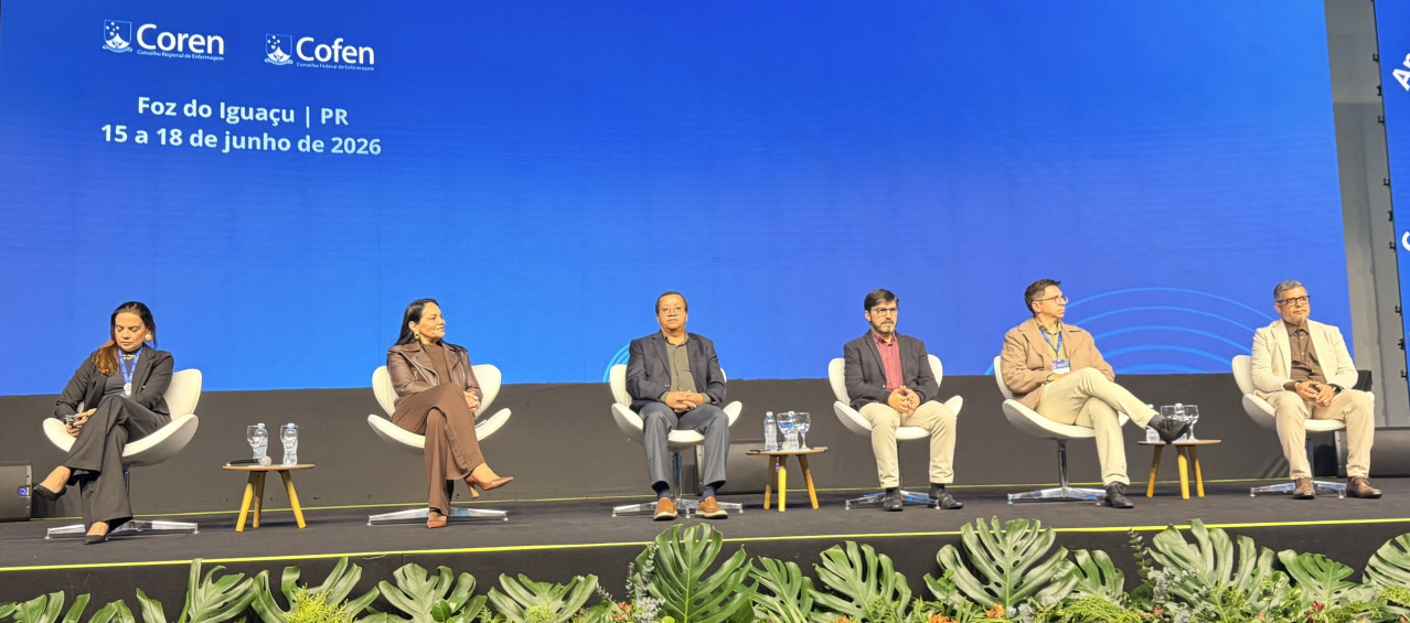 Homens e mulheres no palco de um seminário