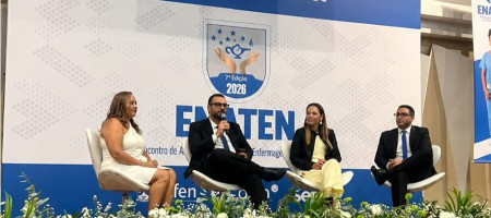 Pessoas sentadas no palco de um auditório