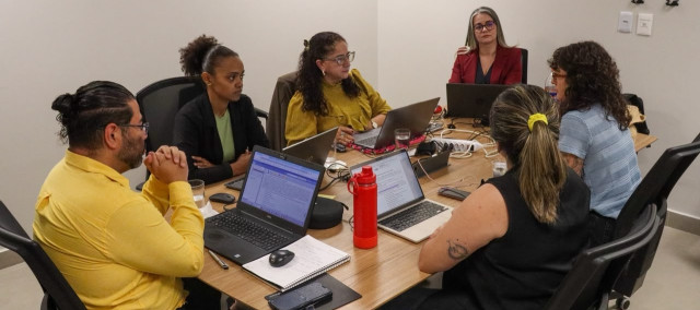 Pessoas sentadas em uma mesa de reunião
