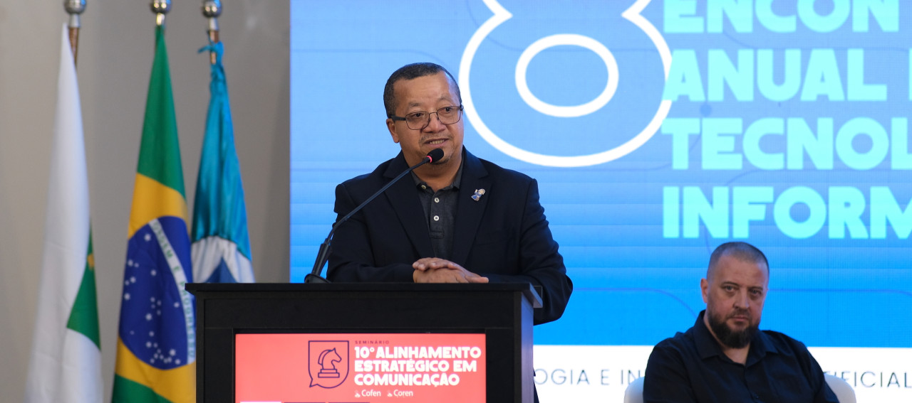 Um homem falando ao microfone no Seminário de Comunicação e TI do Cofen